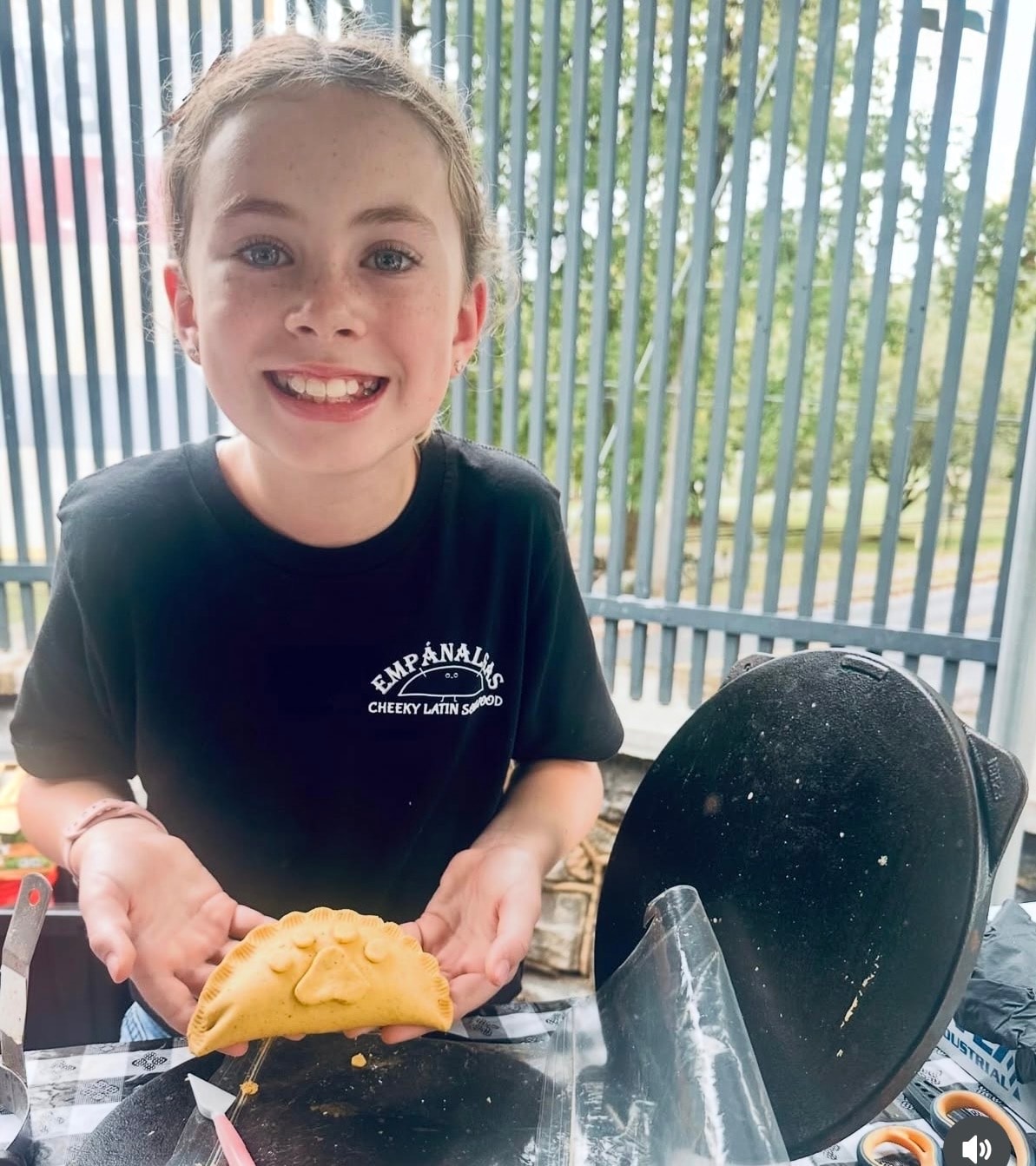 Someone enjoying an Empánalgas empanada at a community event