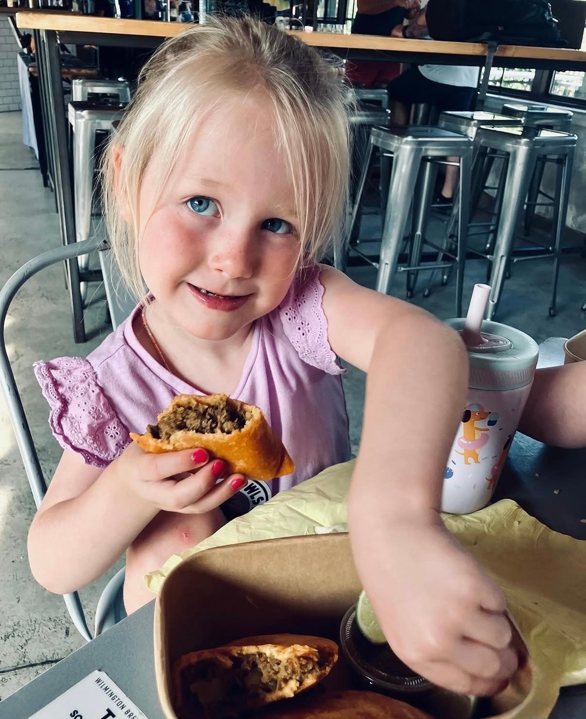 A young guest enjoying an empanada — pockets of joy in action