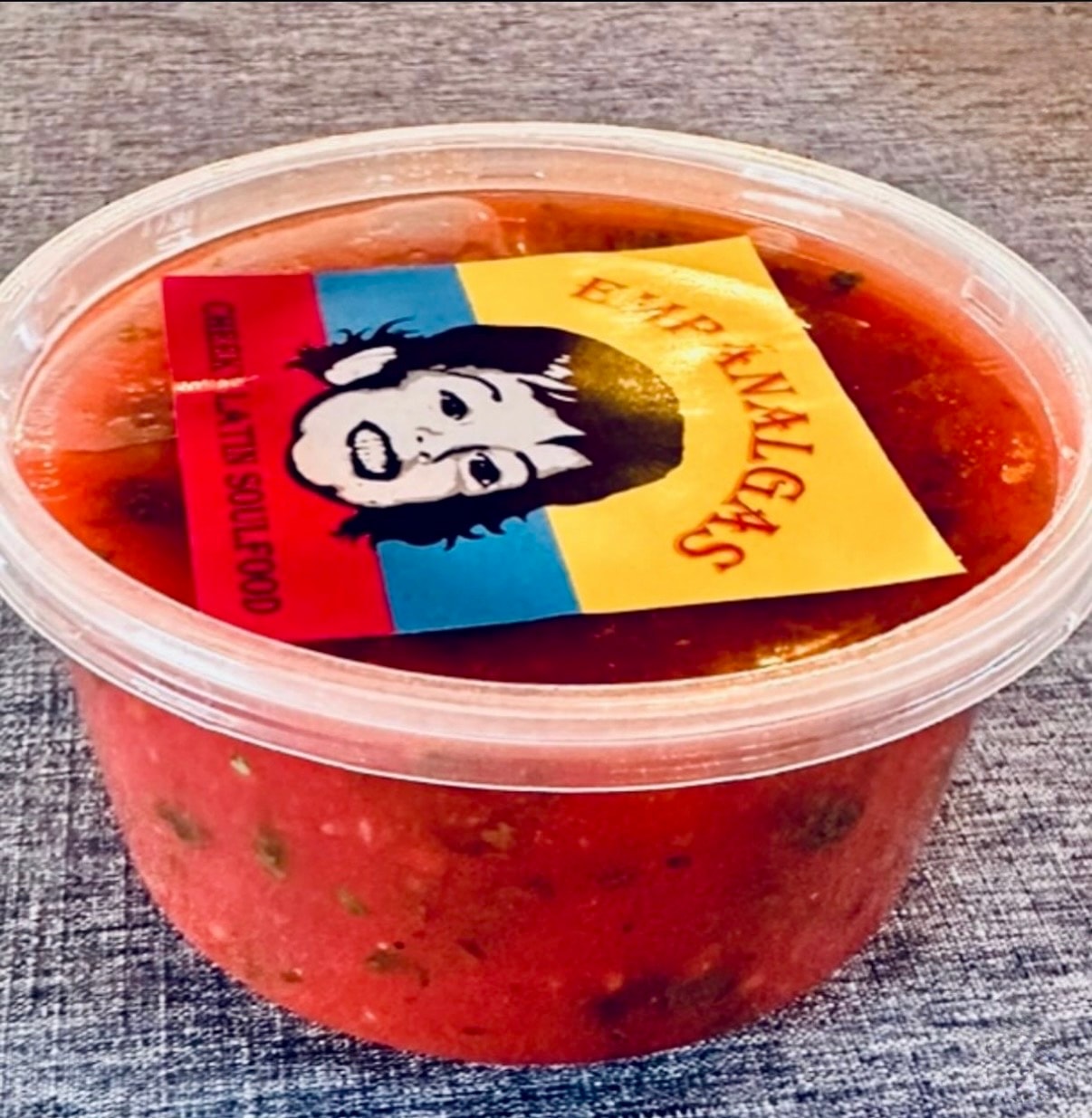 Empánalgas signature sauce container with the brand label